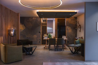 Güney Tyrol, İtalya 'da lüks bir otel. Ilık ışıklandırma, yeşil koltuklar, çiçek duvarları, ahşap mobilyalar ve boynuz duvarı sanatıyla donatılmış..