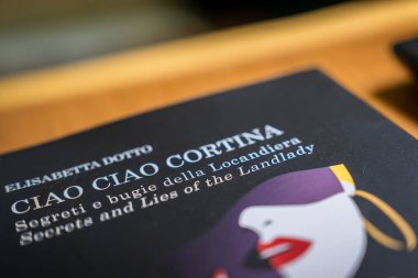 CIAO CIAO CORTINA kitabının kapağı Elisabetta Dotto 'nun, stilize edilmiş kadın yüzü, İtalya' nın Cortina kentindeki ahşap bir yüzeye yerleştirilmiş..