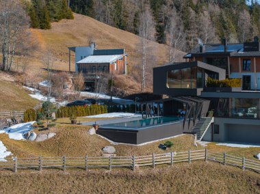 Güney Tyrol, İtalya 'da çağdaş bir otel, kaplamalı bir tasarım, sonsuz havuz, alp zemin, ahşap çit ve yakınlardaki geleneksel bina içeriyor..