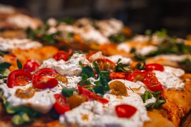 Çeri domatesli, krem peynirli, yeşil otlu ve altın zeytinli taze hazırlanmış pizza. Bergamo, İtalya 'nın geleneksel aromalı..