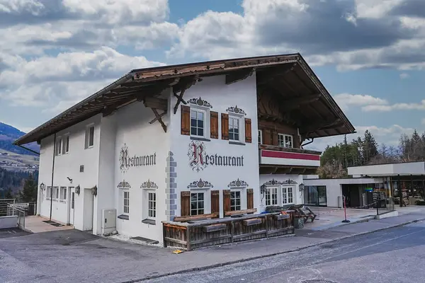 Salzburg, Avusturya 'da ahşap panjurlu ve dik çatılı geleneksel Alp tarzı bina bulutlu bir gökyüzünün altında dağlık bir zemin üzerine kurulmuştur..