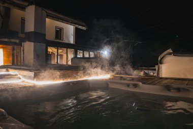 İsviçre 'nin Zermatt kentindeki modern bir alp otelinde, geceleri ahşap döşeme, sıcak aydınlatma ve karla kaplı çatılarda dumanı tüten bir jakuzi bulunur..