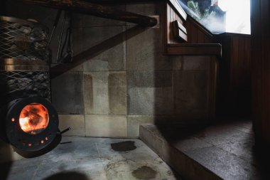 İçi ahşap bir soba, taş döşeli duvarlar, ahşap korkuluklar ve İsviçre 'nin Zermatt kentindeki açık hava manzaralı bir pencereye çıkan merdivenlerle dolu..