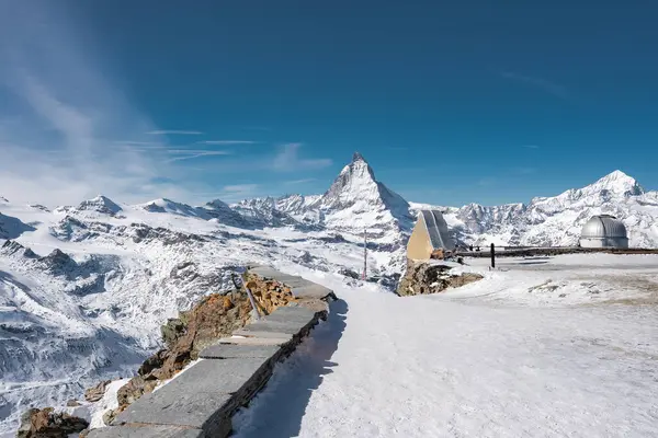 Matterhorn dağı, İsviçre 'nin Zermatt kenti yakınlarında, karlı bir platformda iki kubbeli teleskopun yer aldığı bir gözlemevi ile yükselir..