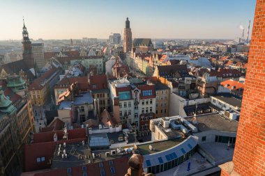 Polonya 'nın Wroclaw kentinin yüksek manzarası, St. Elizabeths Kilisesi, Eski Belediye Binası, kırmızı çatılı binalar ve uzaktaki modern endüstriyel yapılar.