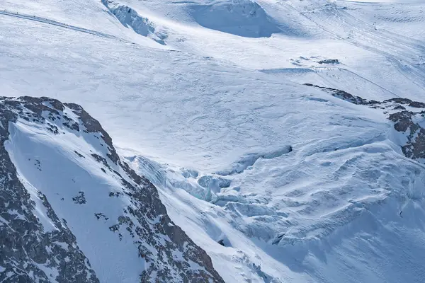 Kar yamaçları ve yarıkları kaplarken, İtalya 'nın Cervinia kenti yakınlarındaki Zermatt bölgesinde kayak kaldırma hatları ve raylar görülebilir..