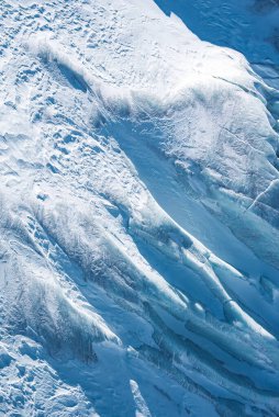 İsviçre 'nin Zermatt yakınlarındaki bir buzulun hava görüntüsü, karmaşık buz oluşumları, yarıklar ve doğal ışıkta değişen mavi ve beyaz tonlarını gösteriyor..