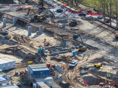 Riga, Letonya 'da etkin inşaat alanı, yeni yollar ve köprüler için vinç, kazıcı, iskele, işçiler ve beton sütunları gösteriyor.