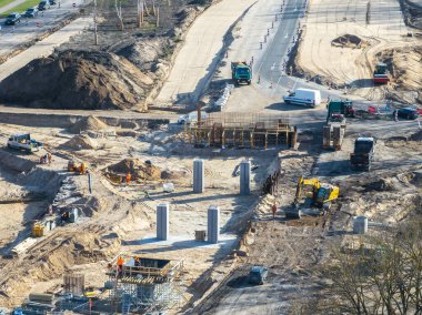 Riga, Letonya 'daki etkin inşaat alanı, ağır makineler, işçiler, beton sütunlar ve yeni yollar ve köprüler için yapısal iskeletler gösteriyor.