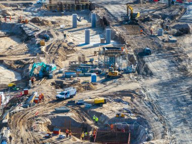 Riga, Letonya 'da, işçiler, kazıcılar, vinçler, çelik kirişler ve yol ve köprü geliştirme için beton sütunlarla aktif inşaat sahası.