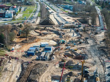 Riga, Letonya 'daki inşaat sahasında büyük bir altyapı projesi sırasında vinçler, kazıcılar, işçiler, beton yapılar ve yönlendirilmiş şeritler görülüyor..