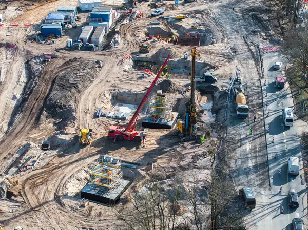 Riga, Letonya 'da vinçler, ağır makineler, işçiler, temel yapılar ve ağaçlarla çevrili yakındaki yollar ile büyük bir inşaat sahası..