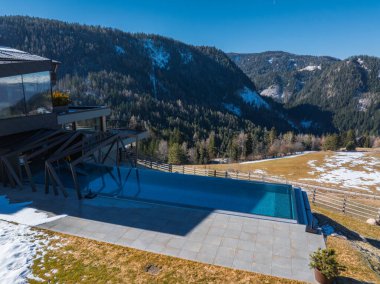 Güney Tyrol, İtalya 'da çağdaş bir otel, sonsuz bir havuz, fayanslı döşeme, kar tozlu zirveler, yoğun ormanlar ve zarif mimari tasarımı var..