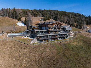 Güney Tyrol, İtalya 'da çağdaş otel, cam pencereler, ahşap aksanlar, teraslar ve çimenli tepeler, ağaçlar ve alp ormanlarıyla çevrili..