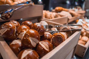 Çubuk kraker, haç kesimli rulo, maşayla ahşap tepsilerde sergilenen, lüks bir ortamda bir büfenin parçası olan ekmekler..