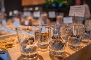 İçinde granola, yulaf, kuru meyve ve İtalyan Alpleri 'ndeki lüks bir otelde ahşap bir yüzey üzerinde kesilmiş muz bulunan kapalı kahvaltı büfesi..