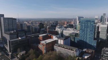 Manchester, İngiltere 'nin hava görüntüsü, modern gökdelenleri, Beetham Kulesi' ni, tarihi binaları ve temiz gökyüzü altında yavaş hareket eden vinçleri gösteriyor..