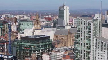 Manchester, İngiltere 'nin hava görüntüsü, belediye binası saat kulesi, CIS Kulesi, Beetham Kulesi ve yavaş çekimli inşaat vinçleri.