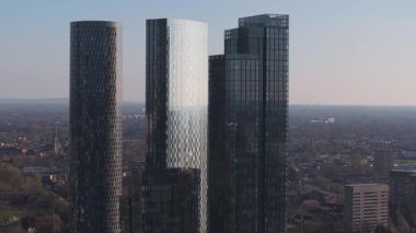 Manchester, İngiltere 'nin hava manzarası, modern gökdelenler, bir kilise kulesi, ve şehir ve yeşil manzaraların karışımı..