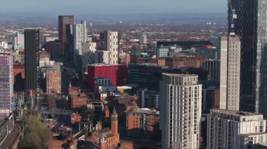 Manchester, İngiltere 'nin hava görüntüsü, Beetham Kulesi, modern ve tarihi binalar, hareket eden trenler ve uzak tepeli açık gökyüzü.