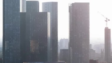 Manchester, İngiltere 'nin hava görüntüsü, yüksek binaları olan modern bir gökyüzü, yapım aşamasında olan kum saati şeklindeki bir gökdelen ve kentsel gelişim.