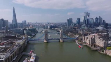 Thames Nehri üzerindeki Tower Köprüsü 'nün havadan görünüşü. Tekneler ve kanolar hareket halinde. Londra şehri Gherkin gibi gökdelenler görülebilir..