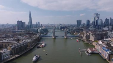 Thames Nehri üzerindeki Tower Bridge 'in Parça, Telsiz ve Gherkin binalarıyla görüntüsü. Tekneler nehir boyunca dağılmış bulutların altında hareket eder..