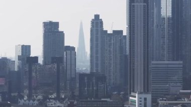 Yavaş çekim ile sisli bir günde Londra 'nın kentsel ufuk çizgisine modern gökdelenler ve Londra' nın Gözü eşlik ediyor..