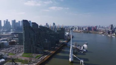 O2 Arena, Thames Nehri, Canary Wharf silueti, köprüler, botlar ve hareket halindeki modern ve tarihi mimariyle Londra 'nın havadan görünüşü.
