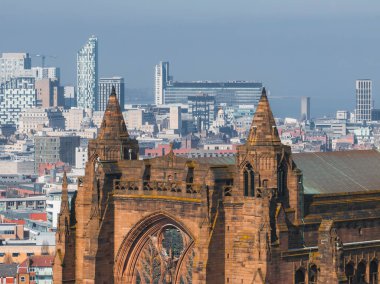 Liverpool Katedrali 'nin taş işçiliğini ve kulelerini vurgulayan hava manzarası, Royal Liver Binası ve arka planda modern şehir manzarası.
