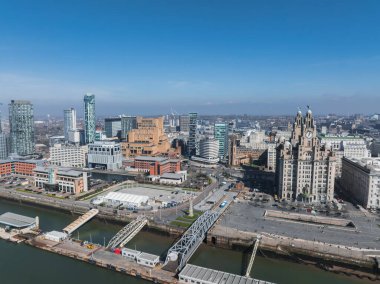 Liverpool 'un havadan görünüşü Kraliyet Karaciğer Binası, rıhtım rıhtımı, bir köprü, modern yüksek binalar ve açık mavi gökyüzü altında tarihi mimari.