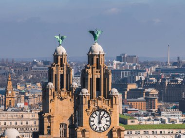 Liverpool 'un, tarihi ve modern şehir yapılarıyla çevrili saat kuleleri ve karaciğer kuşlarıyla Kraliyet Karaciğer Binası' nı gösteren hava manzarası..
