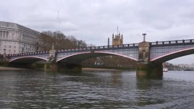 Arka planda Westminster Sarayı olan Lambeth Köprüsü manzarası. Kamera kayıkları ve sakin Thames Nehri 'ni gösteriyor..