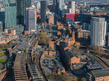 Manchester, İngiltere 'nin hava görüntüsü, Beetham Tower gibi modern gökdelenleri gösteriyor, tarihi kırmızı tuğla binalar, demiryolu rayları, ve güneşli bir günde kanallar.