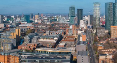 Beetham Tower, modern gökdelenler, tarihi binalar, işlek yollar ve güneşli bir günde açık mavi gökyüzünün yer aldığı Manchester, İngiltere 'nin hava manzarası..