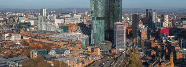 Manchester, İngiltere 'nin hava görüntüsü, Deansgate Meydanı gökdelenleri, Manchester Merkez, Belediye Binası saat kulesi, yollar, tramvay rayları ve uzak tepeler.