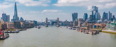 Thames Nehri 'nin üzerindeki Tower Bridge' in havadan görüntüsü, Londra 'nın siluetindeki Parça ve Telsiz binası dağınık bulutlarla kaplı açık bir gökyüzünün altında..
