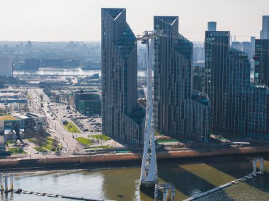 Thames Nehri 'ni geçen Emirates Hava Hattı teleferiğinin hava görüntüsü, modern yüksek binalar ve Greenwich Yarımadası' ndaki kentsel altyapı.