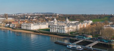 Greenwich, Londra 'daki eski Kraliyet Donanma Koleji' nin hava perspektifi, kubbeli binalar, Thames Nehri, botlar, yeşil alanlar ve kentsel çevre.