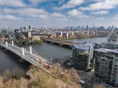 Londra 'nın Thames Nehri, Chelsea Köprüsü, Albert Köprüsü, modern eğri binalar, Çömlek ve bulutların altındaki şehir yeşilliğini gösteren hava perspektifi.