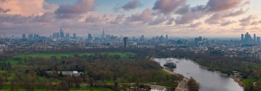 Londra 'nın hava perspektifinde Çömlek, Kanarya İskelesi, kıvrımlı bir nehri olan yeşil bir park ve bulutlu gökyüzü altında şehirlerin yayılması.