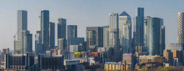 Londra 'daki Canary Wharf' ın panoramik görüntüsü, One Canada Meydanı ve diğer gökdelenlerin yerleşim ve ticari binalarla çevrili olduğunu gösteriyor..