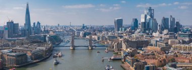 Thames Nehri üzerindeki Tower Bridge, The Shard, Walkie Talkie binası, St. Pauls Katedrali ve hareketli tekneleri gösteren Londra hava manzarası..