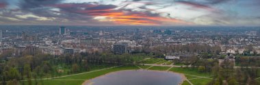 Hyde Park 'ın Serpentine Gölü, Kensington Sarayı ve Londons şehir manzarasının modern ve tarihi mimarisi ile perspektifi.