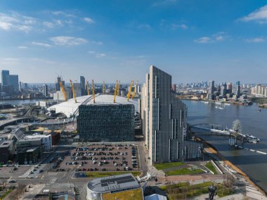 O2 Arenas beyaz kubbesi, Thames nehri, yaya köprüsü ve gündüz vakti Canary Wharf gökdelenleri ile Londra 'nın havadan görünüşü..