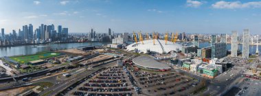Beyaz kubbesi ve sarı desteğiyle Thames Rıhtımı 'nda Kanarya Rıhtımı' nın karşısındaki yollar ve binalarla çevrili Londons O2 Arena 'nın hava görüntüsü..