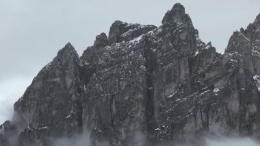 Uçsuz bucaksız Dolomite dağları, karla kaplı yamaçlar, pürüzlü kaya oluşumları ve hareketli bulutlar sakin bir kış manzarası yaratıyor..