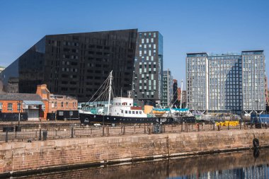 Liverpool 'da açısal Liverpool Müzesi, kenetlenmiş gemi, küçük tekneler, modern cam binalar ve tarihi tuğla yapılar yer alıyor..