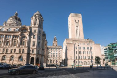 Liverpool Limanı, George Rıhtım Havalandırma Kulesi ve açık mavi gökyüzü altında Royal Liver Binası ile sokak manzarası.