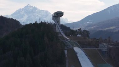 Avusturya 'nın Innsbruck kentindeki Bergisel Kayak Atlayışı' nın havadan görünüşü modern tasarımını ve etrafındaki kar örtülü Alpleri göstermektedir..
